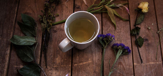 cup of ayurvedic tea with herbs around it