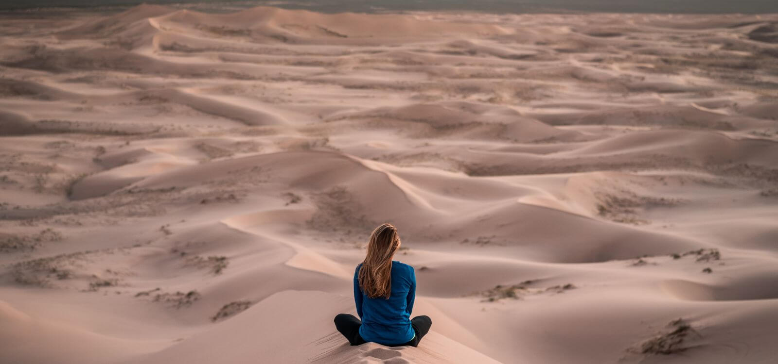 woman meditating in dunes