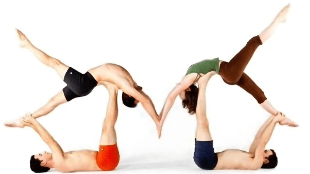 two pairs performing mirrored acro yoga, bases lying on backs lifting partners who arch and touch hands midair