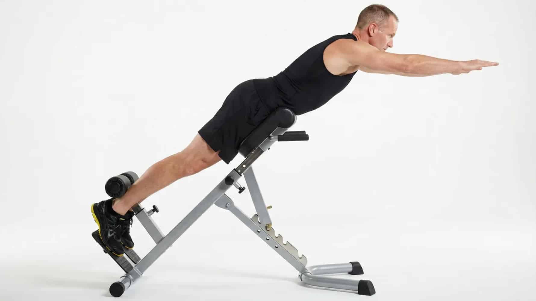 man performing back extension on 45-degree roman chair with arms extended forward, maintaining straight body alignment