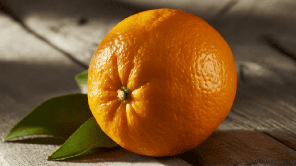 orange whole fruit on wooden surface with green leaves naturally high in potassium for healthy fruit diet and nutrition