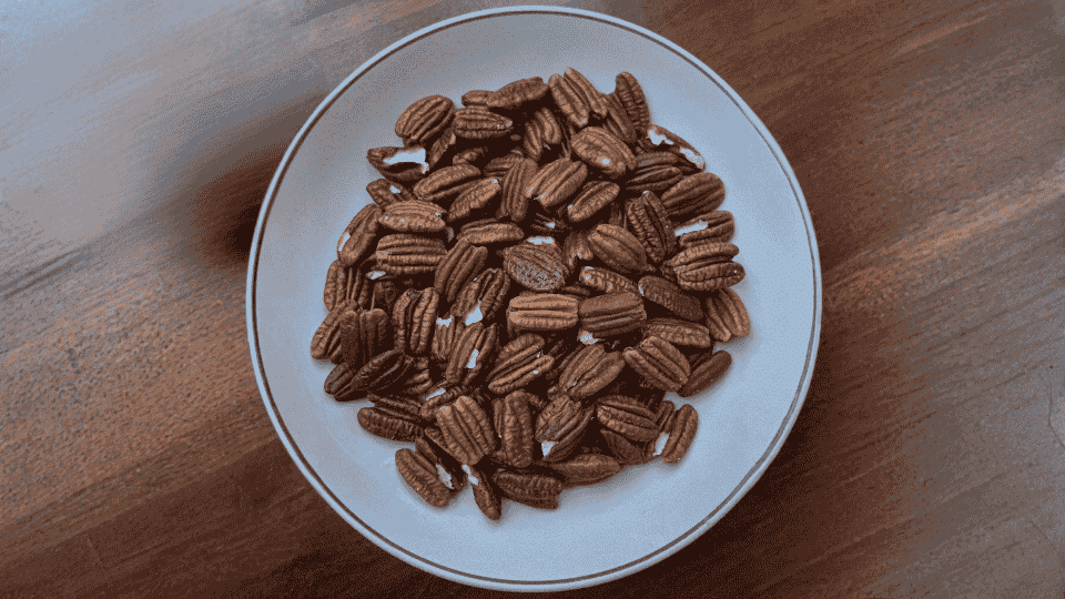 pecans inplate on wooden table potassium rich nuts healthy snack ingredient for balanced diet and nutrition.