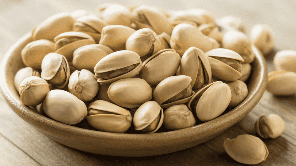pistachios in shells and kernels on wooden surface naturally high in potassium for healthy nut snack and diet (1)