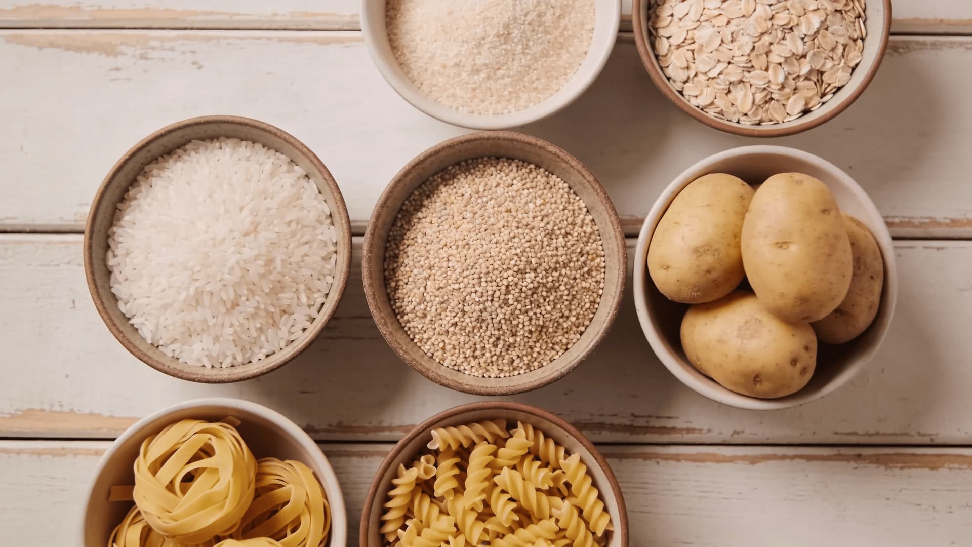 rice, quinoa, oats, potatoes, and gluten-free pasta arranged in bowls for low histamine diet starches