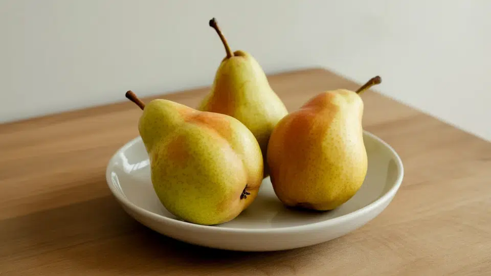 three fresh pears on a white plate, a low histamine fruit choice for sensitive diets