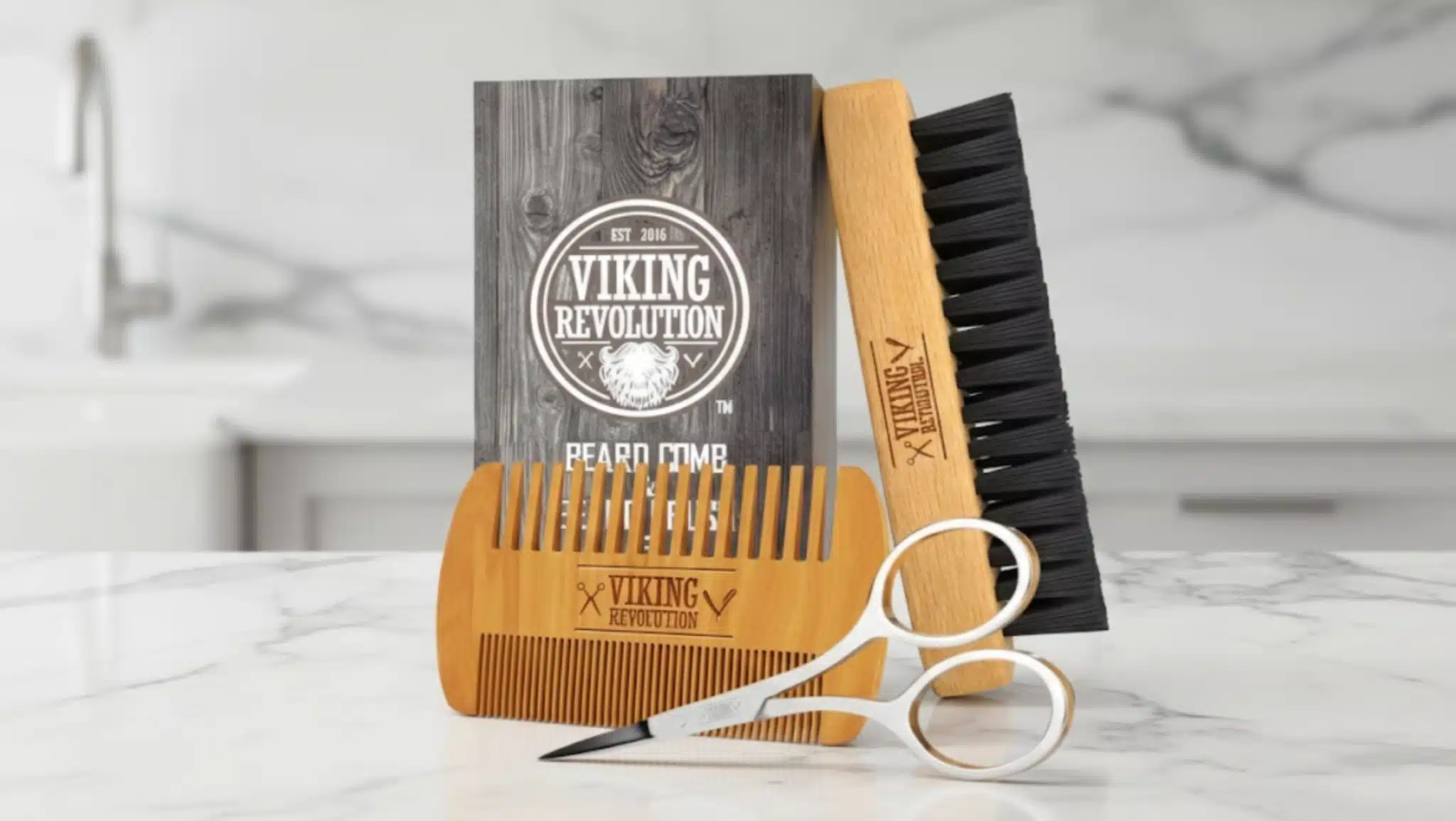 viking revolution beard grooming kit with a wooden comb, a beard brush, scissors, and a branded box on marble countertop