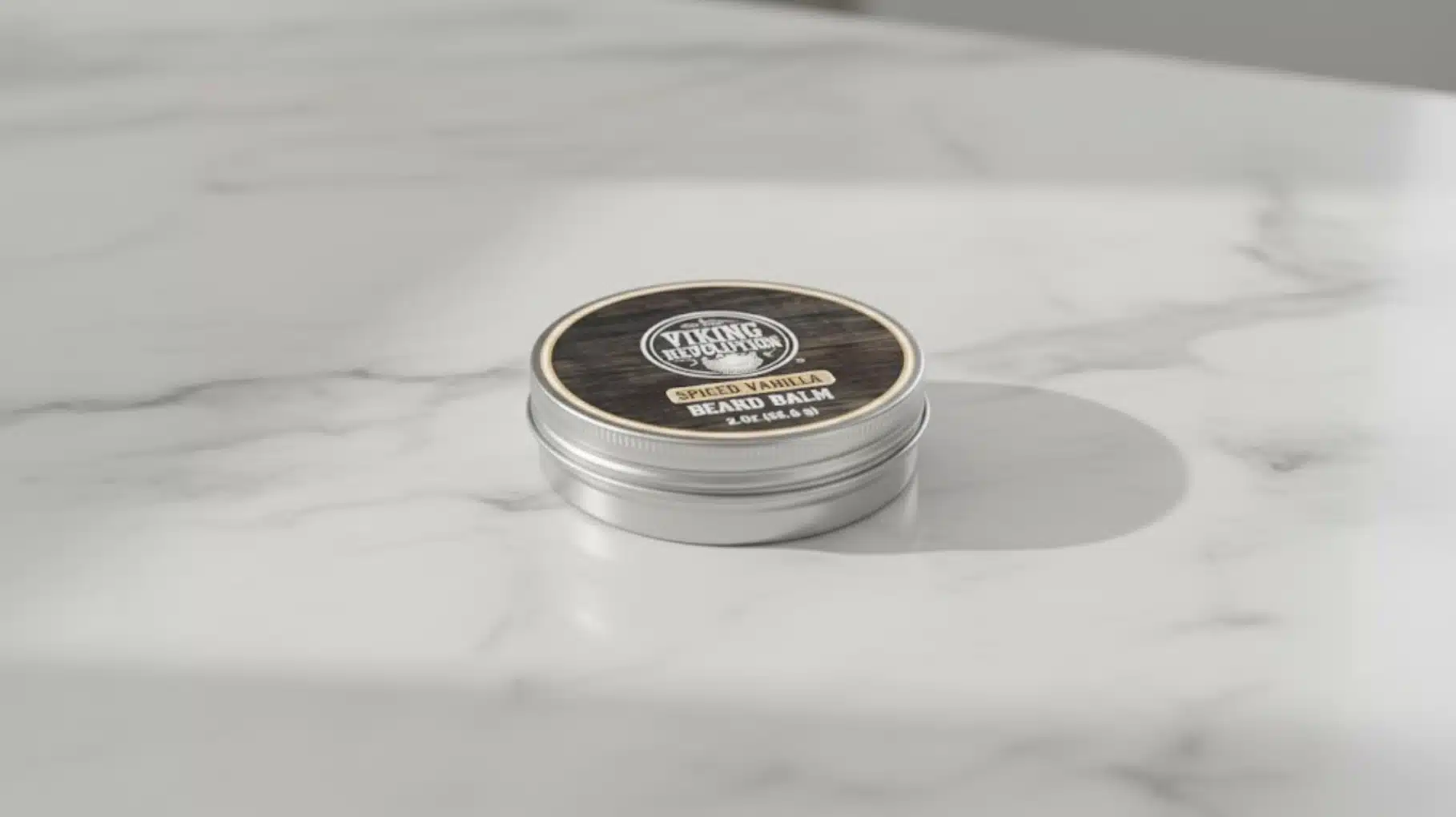 viking revolution spiced vanilla beard balm tin container on marble surface, natural men’s beard grooming product