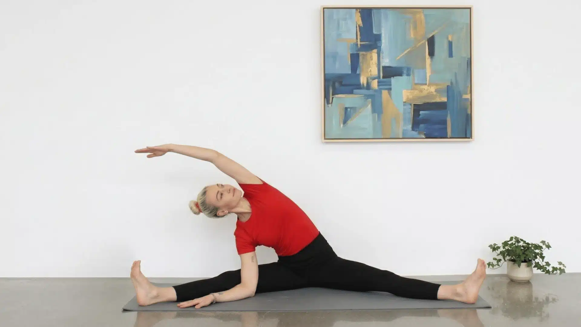 a picture showing women do  twisting movements indoor in red tshirt and black pants