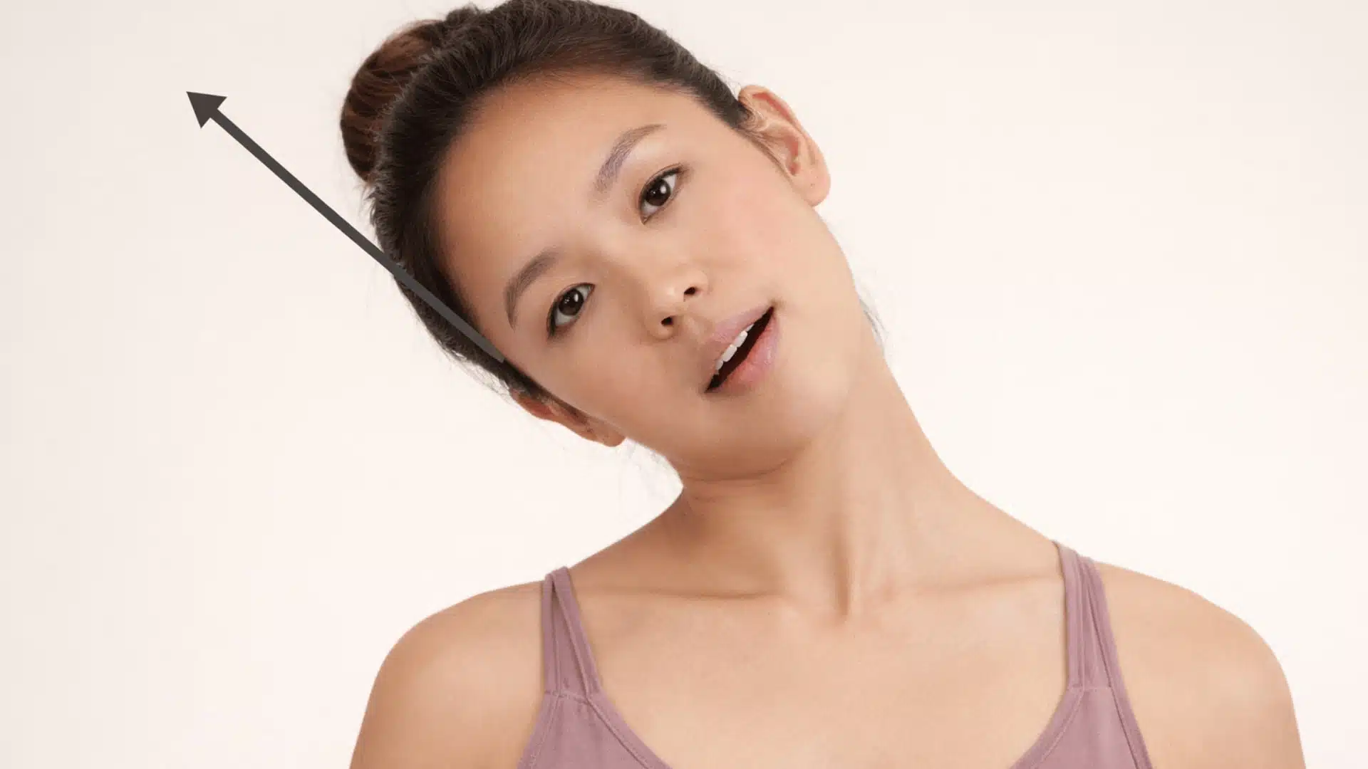 a woman performing a gentle neck stretch for tmj relief, tilting her head with a relaxed expression