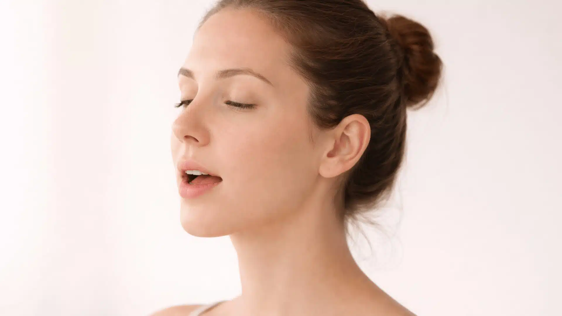 a woman with her mouth naturally open and eyes closed, demonstrating a relaxed, peaceful expression.