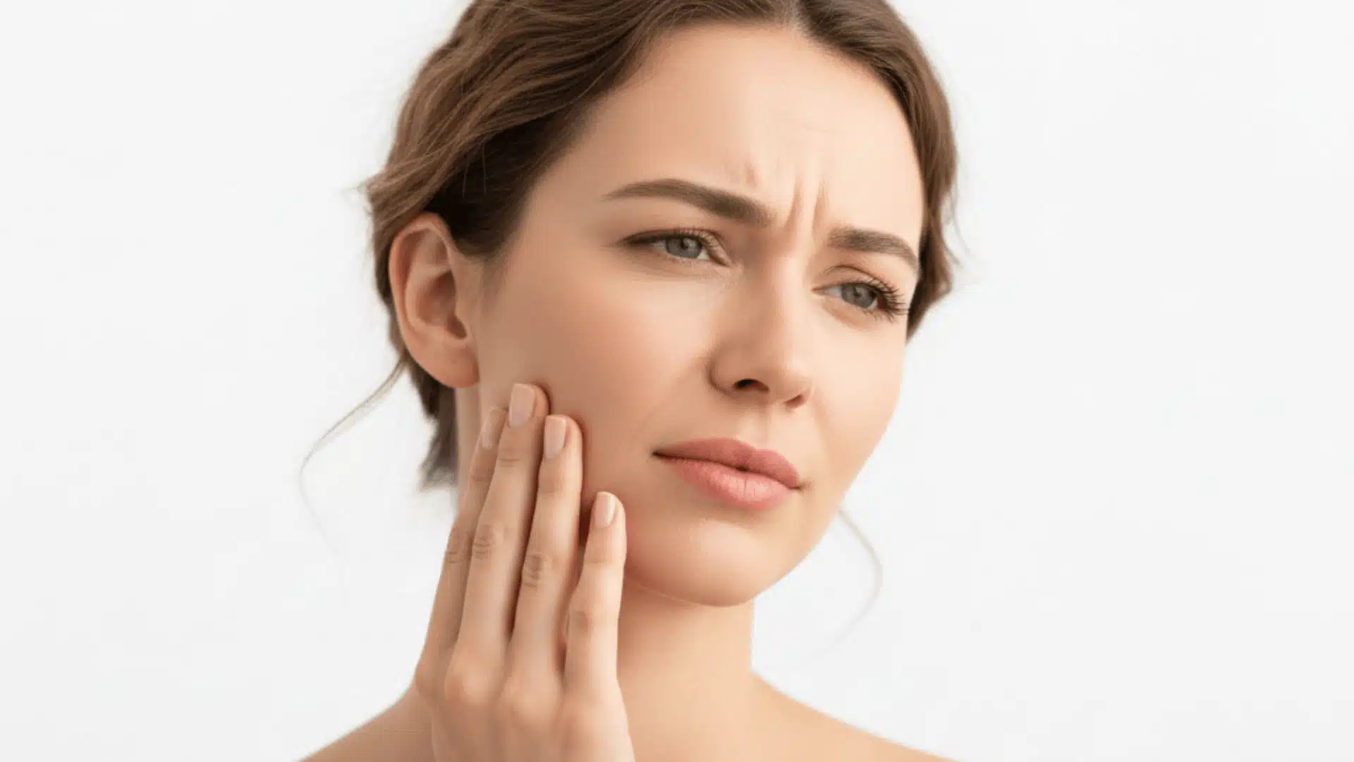 close-up photorealistic image of a woman in her 30s pressing her jaw in pain against a white background