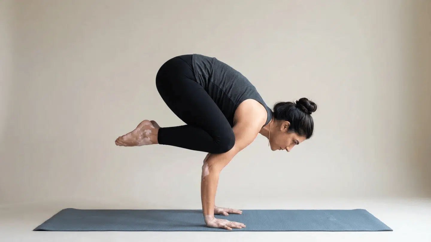 crow pose bakasana arm balance with knees resting on upper arms while lifting feet from floor engaging core