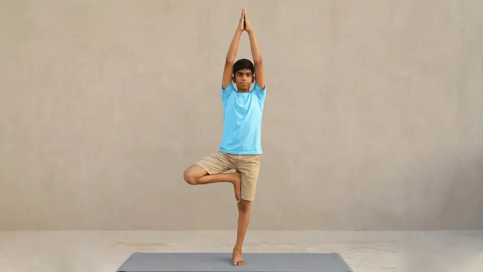 tree pose vrksasana balancing on one leg with the other foot placed on inner leg hands together building focus and stability