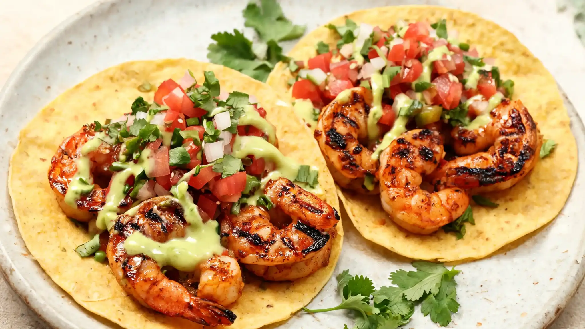 grilled shrimp tacos with chipotle-lime seasoning, topped with avocado dressing and pico de gallo