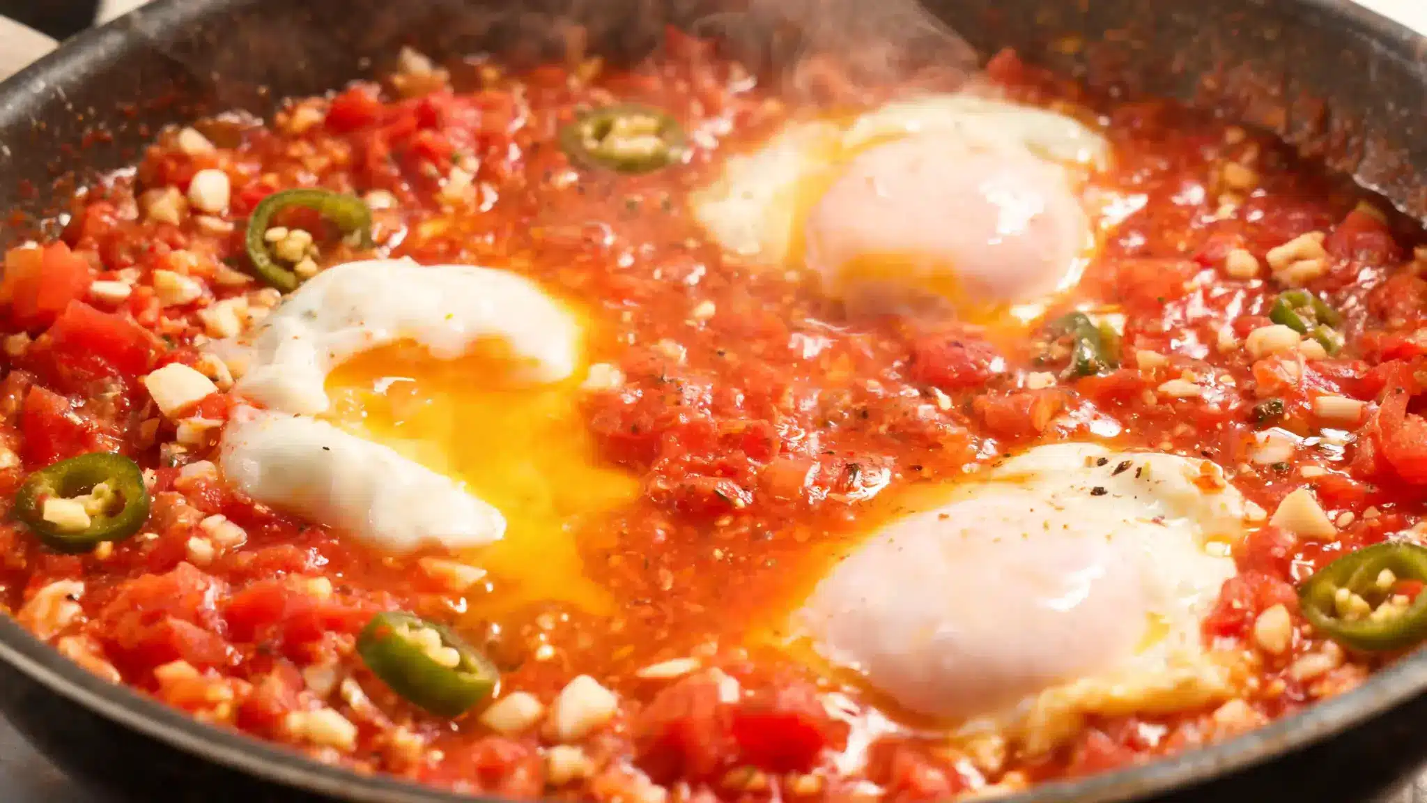 poached eggs in a vibrant tomato salsa with garlic and jalapeño for a healthy, flavorful meal