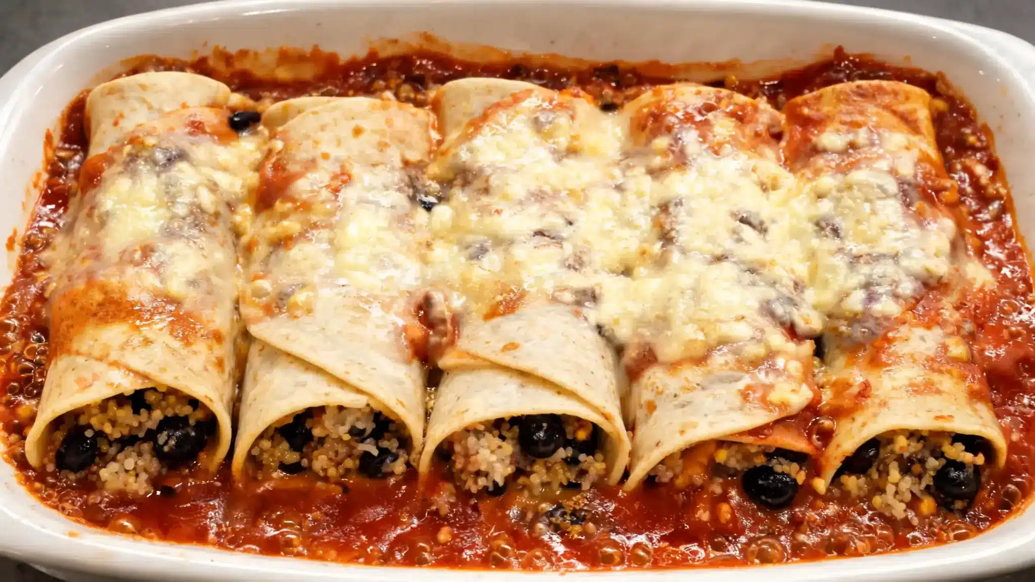 quinoa and black bean vegan enchiladas with a homemade enchilada sauce and light cheese