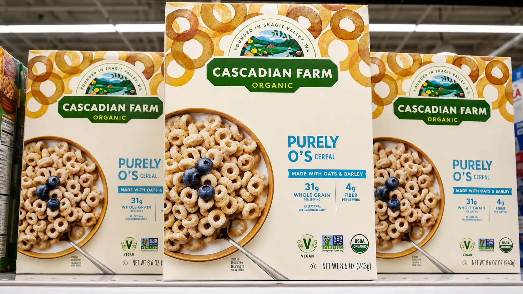 three cascadian farm purely os cereal boxes displayed on a grocery store shelf with clean packaging visible