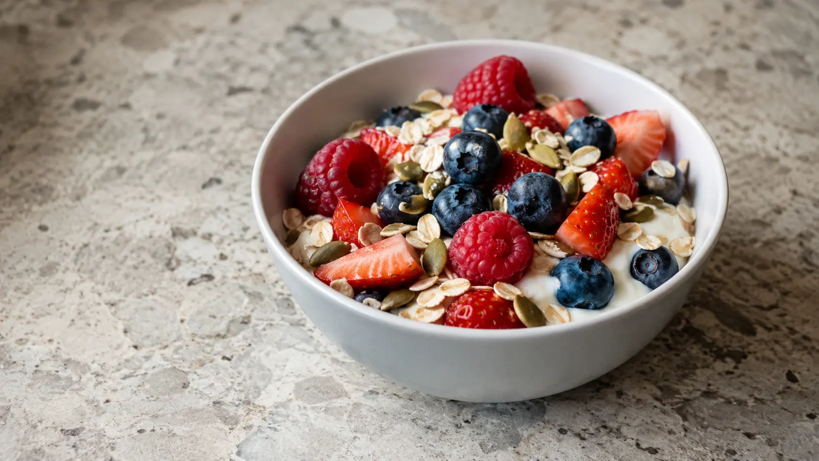 yogurt with pumpkin seeds oats and berries in a bowl