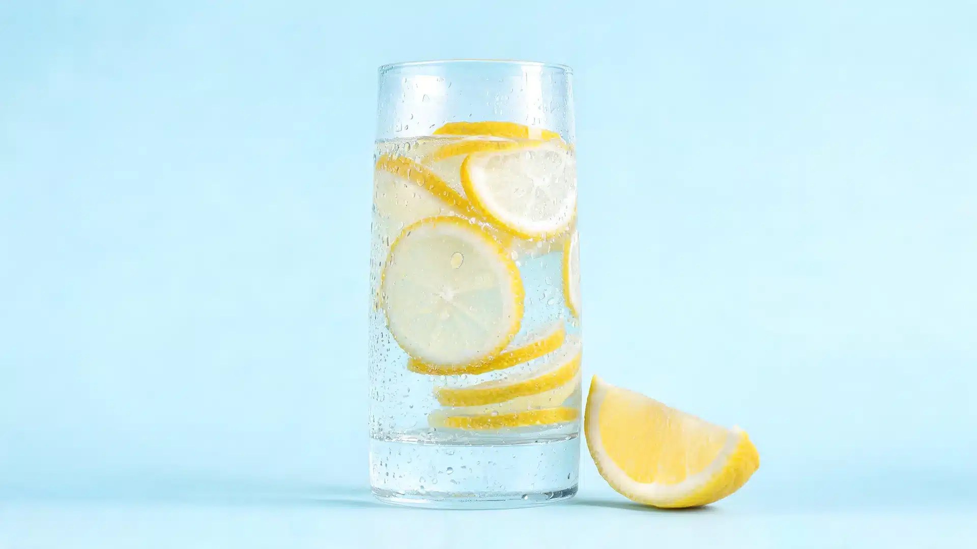 lemon-kidney-detox-juice-with-fresh-lemon-slices-in-a-tall-glass-on-a-light-blue-background