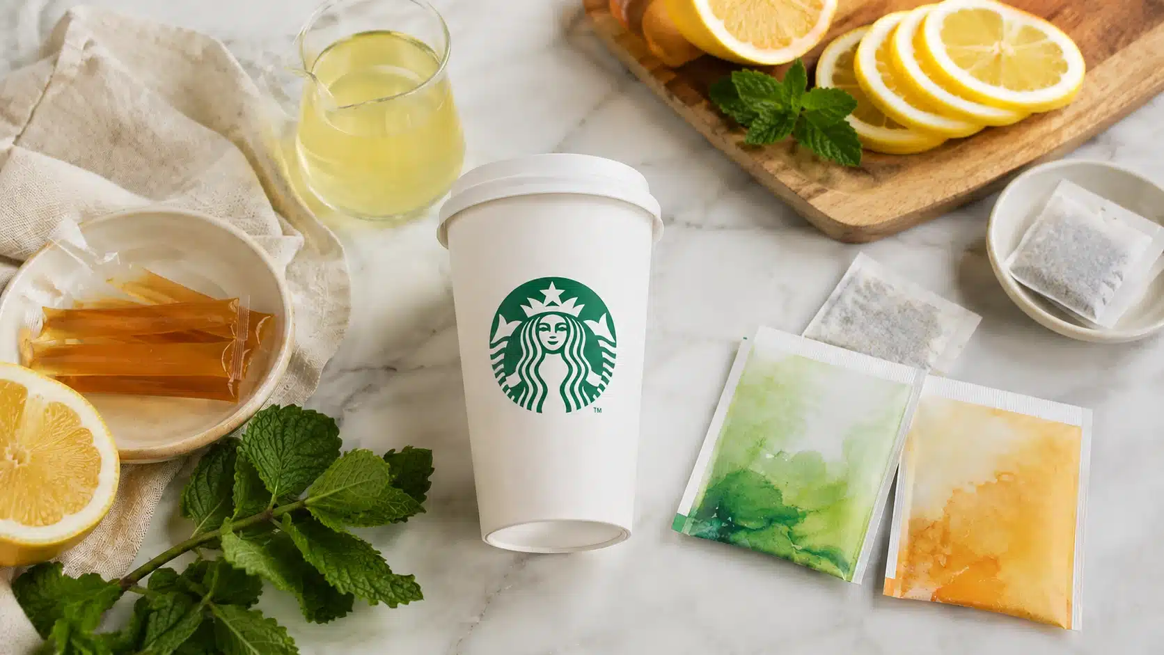 medicine ball tea ingredients with lemon mint honey lemonade and tea packets on a marble counter