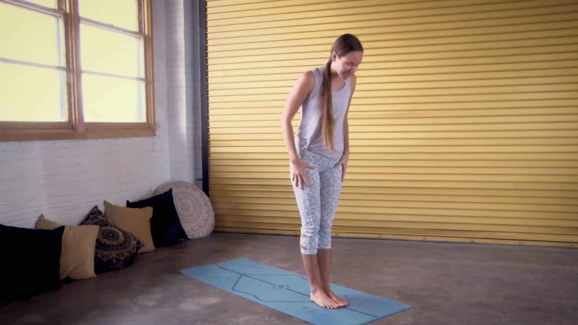 person setting up for a low lunge stretch with soft knees and hands near the floor
