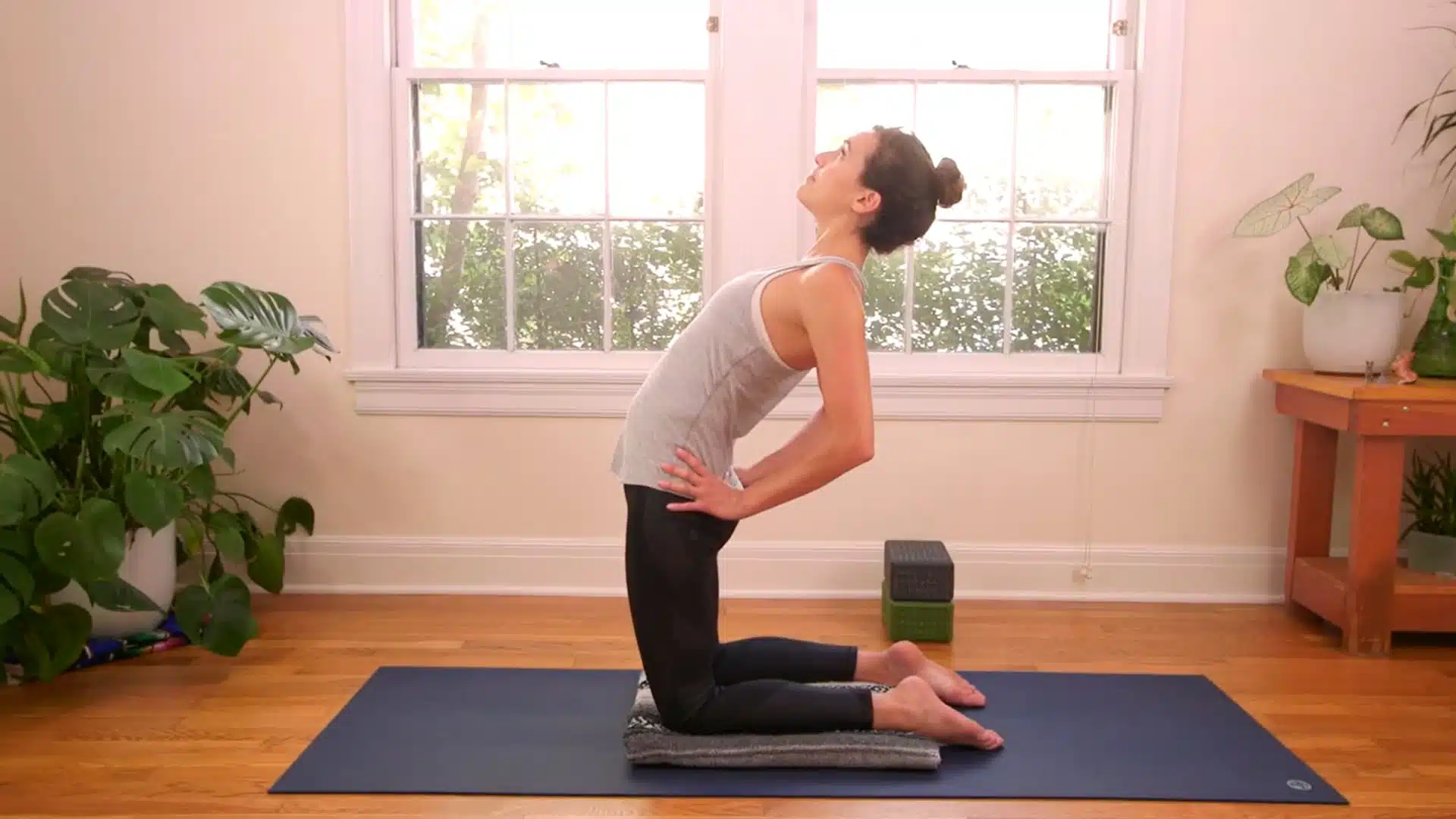 Hands on lower back chest lift camel pose preparation