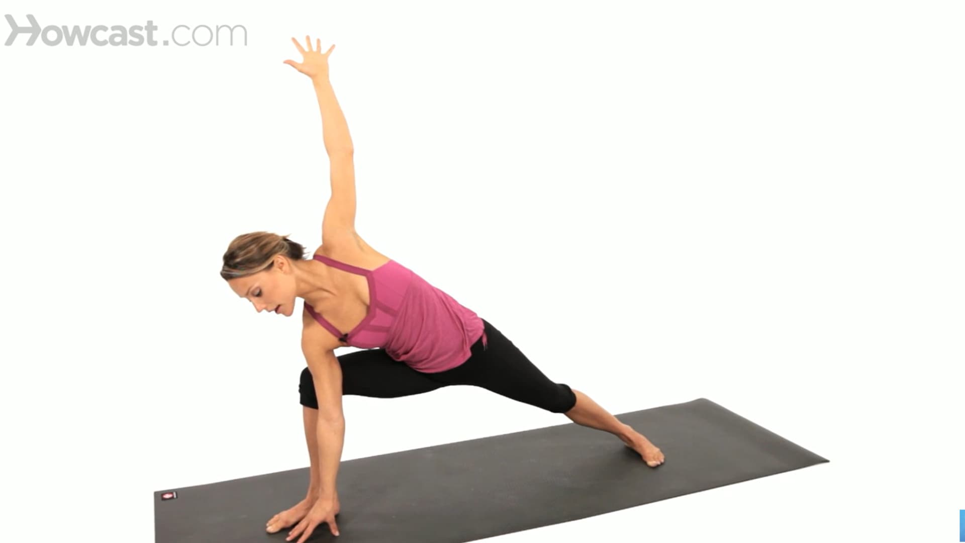 woman holds hand-to-floor side angle pose with one arm reaching up, chest open, and legs steady on a mat (1)