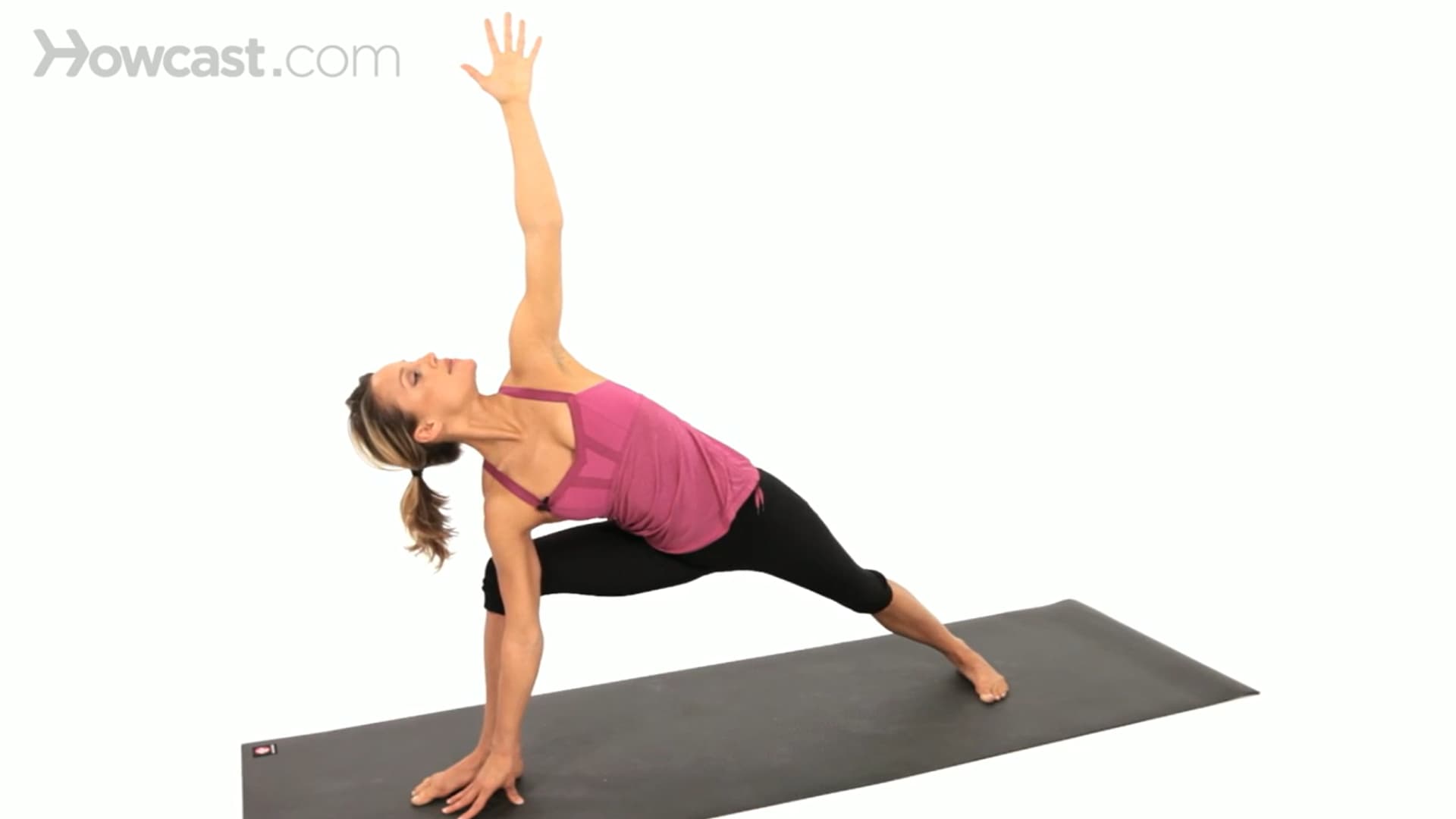 woman holds side angle pose with one hand on the mat, chest open, and top arm reaching upward steadily