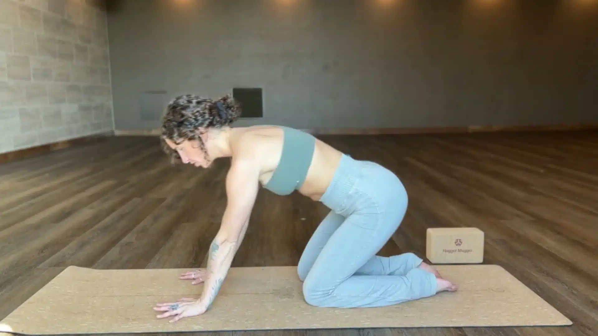 woman moving from tabletop as she walks her hands forward to enter puppy pose