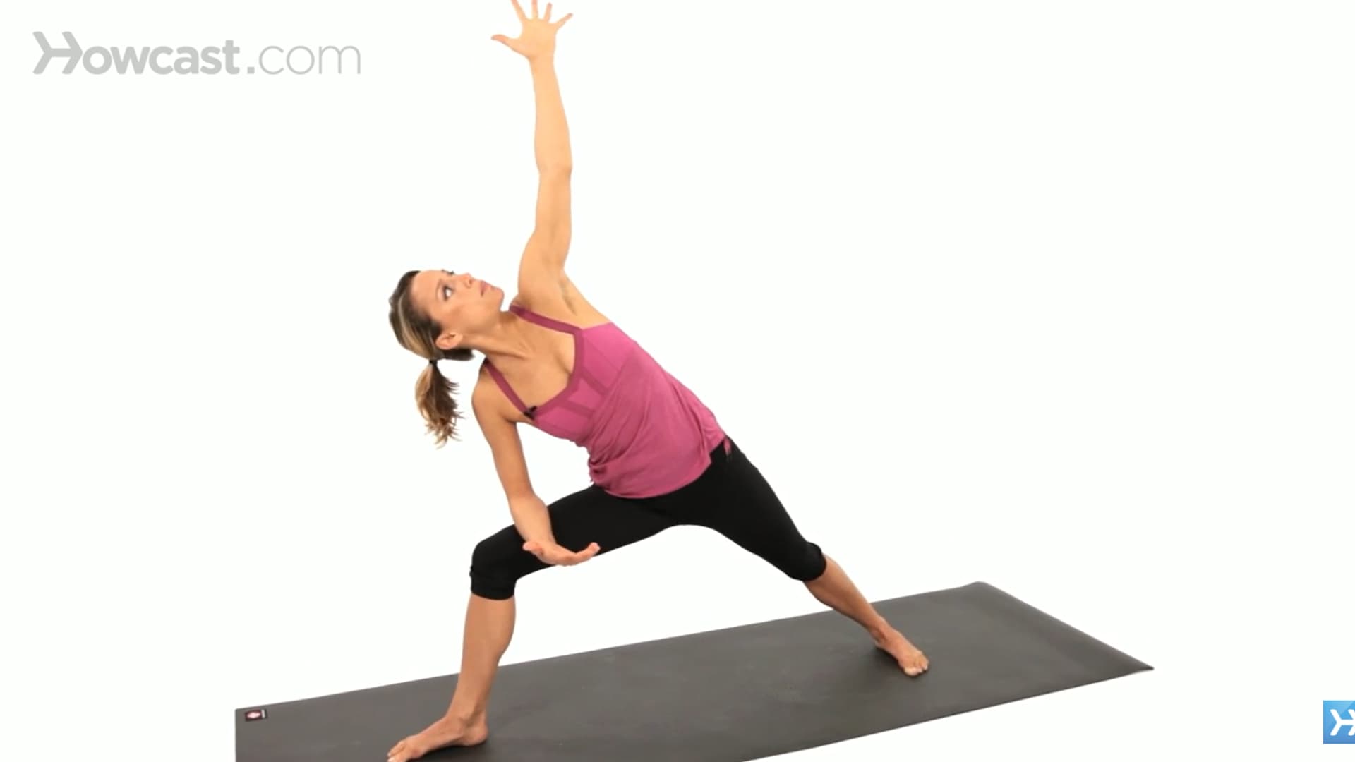woman practices side angle pose with forearm on thigh and top hand on hip in a wide stance mat pose (1)